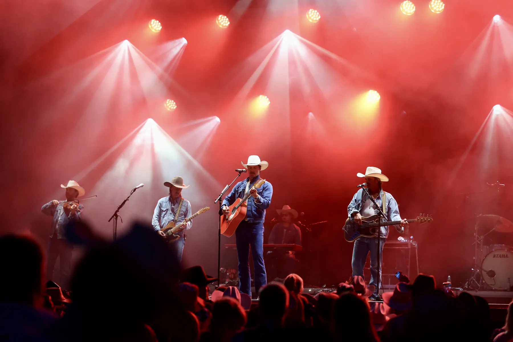 Bandet på scenen under røde scenelys på Taste of Country.