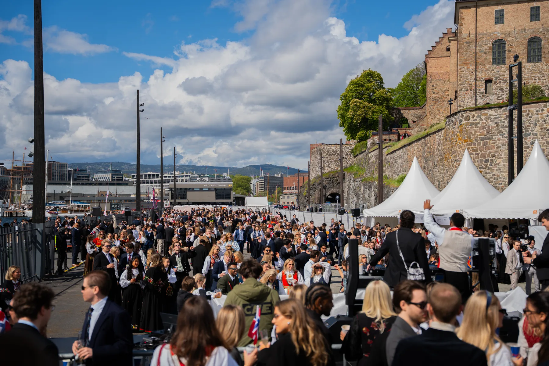Festivalgjester på Cruisekaia under Nasjonalfesten, med Akershus festning i bakgrunnen.